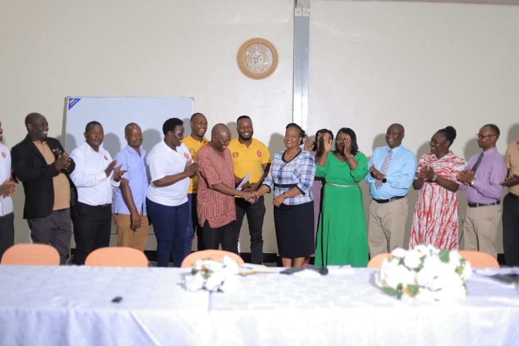 Odongo Sammy , Assistant Commissioner,PES,Ministry of Education and Sports handing over the letter from Permanent Secretary to Mrs. Kyambadde Amelia, Resident director Seroma Christian High School.